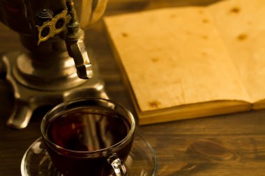 Tea still life with samovar on wooden background. Empty open an old vintage book. Russia autumn.