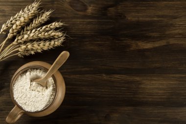 pot of flour and wheat ears on wooden background. homemade, menu, recipe, mock up
