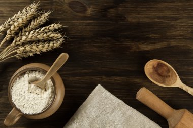 pot of flour, wheat ears, kitchen utensils on wooden background. homemade, menu, recipe, mock up