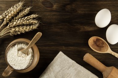 pot of flour, wheat ears, kitchen utensils on wooden background. homemade, menu, recipe, mock up