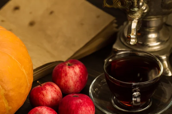 Tea still life with samovar, apples, ripe orange pumpkins, maple leaves on wooden background. Thanksgiving, autumn. — Stockfoto