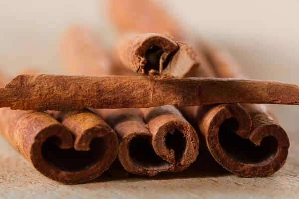 Macro, whole cinnamon sticks on wooden background — Stock Photo, Image