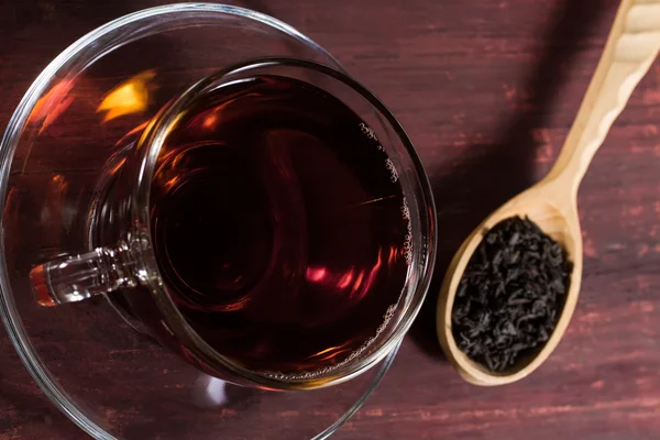 A xícara preta de chá quente na mesa de madeira — Fotografia de Stock