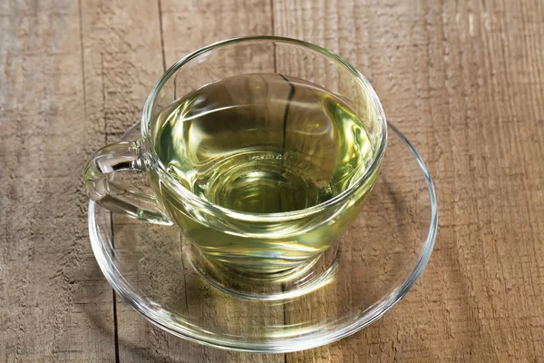 Tasse de thé vert chaud sur table en bois — Photo