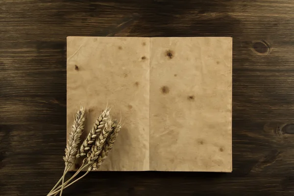 Open old vintage book on the aged wooden background. ears of wheat. homemade, menu, recipe, mock up — Stock Photo, Image