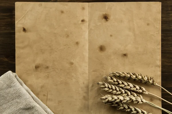 open old vintage book on the aged wooden background. wheat, cloth. Homemade, menu, recipe, mock up