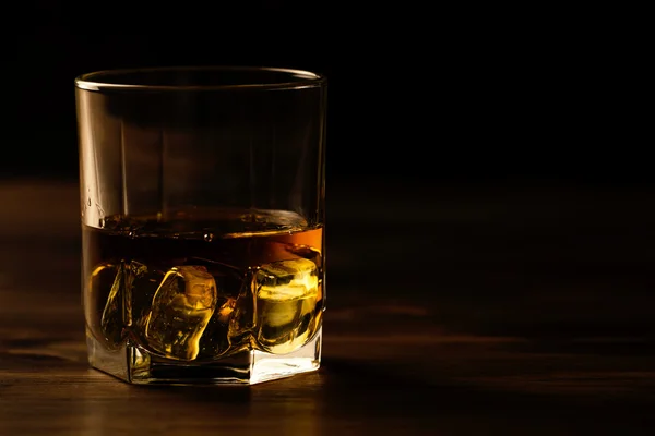 Vaso de whisky con hielo sobre una mesa de madera. Coñac, brandy . — Foto de Stock