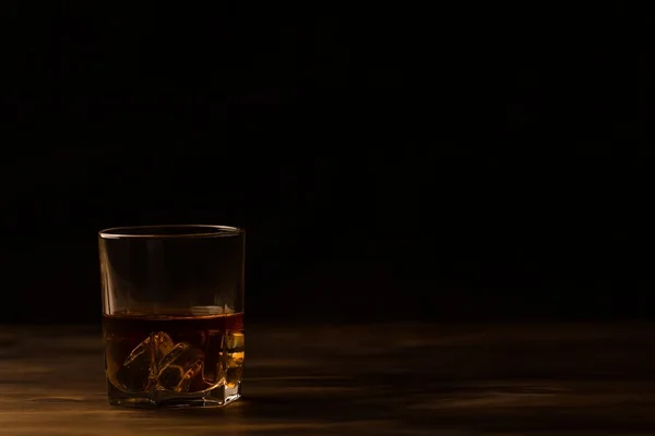 Vaso de whisky con hielo sobre una mesa de madera. Coñac, brandy . —  Fotos de Stock