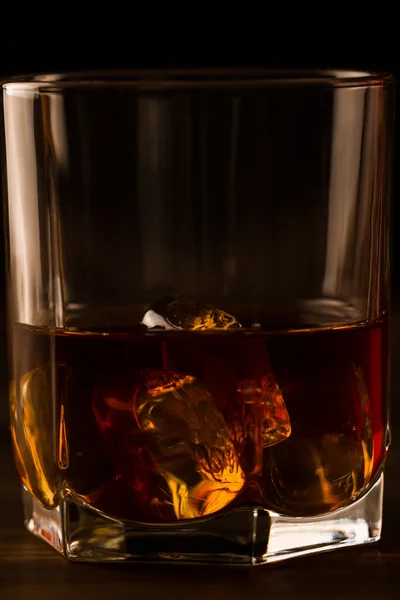 Cam ahşap bir masa üzerinde buzlu viski. Konyak, brandy. — Stok fotoğraf