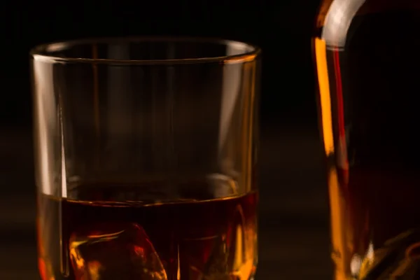 Cam ahşap bir masa üzerinde buzlu viski. Konyak, brandy. — Stok fotoğraf