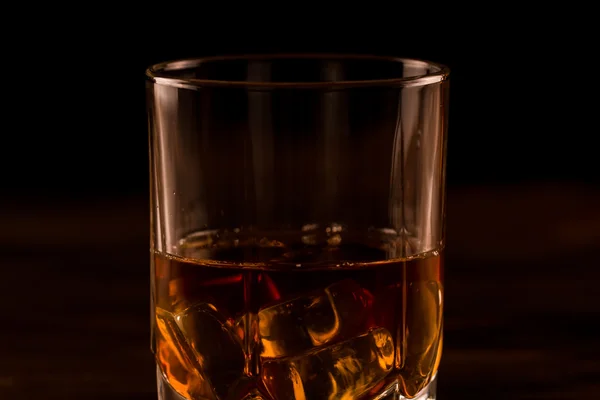 Vaso de whisky con hielo sobre una mesa de madera. Coñac, brandy . — Foto de Stock