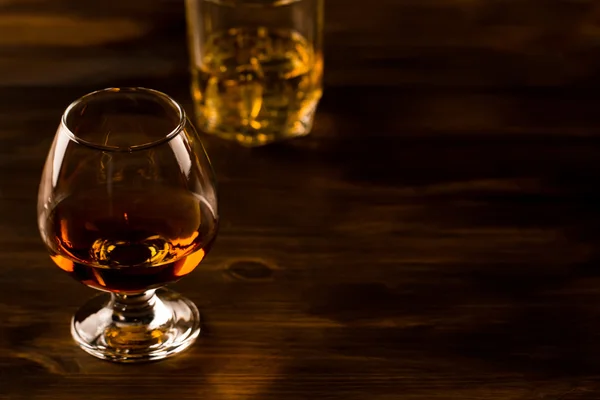木製テーブルの上の氷とウイスキーのガラス。コニャック、ブランデー. — ストック写真