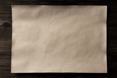sheet old vintage paper on the aged wooden background. Parchment