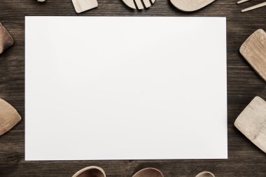 white sheet of paper with utensils on the old wooden background. Mock up