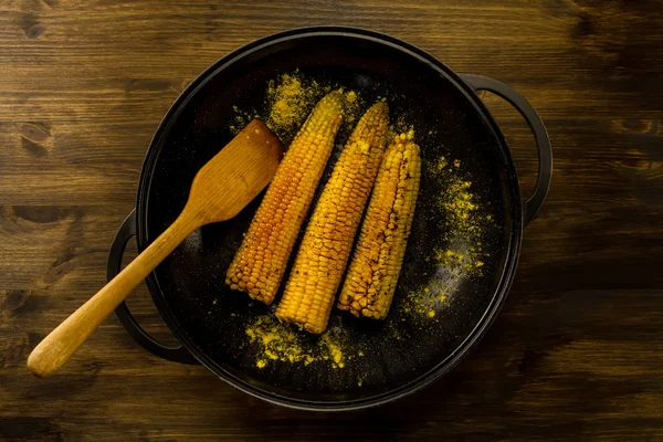 Maíz frito en una sartén con especias sobre fondo de madera. Comida vegetariana saludable . — Foto de Stock