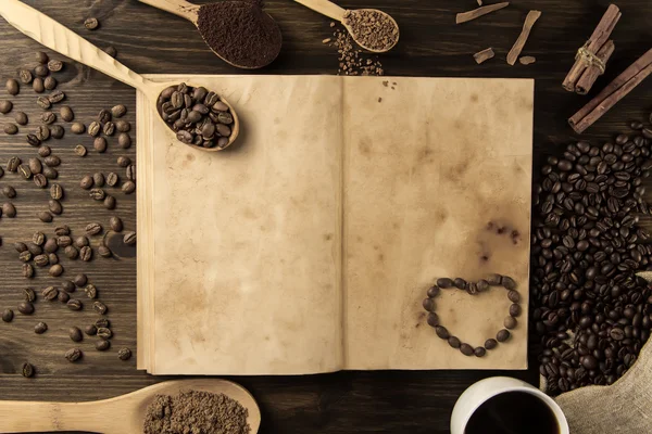 Rostade kaffebönor på gamla vintage öppen bok. Meny, recept, prototyper. Trä bakgrund. — Stockfoto