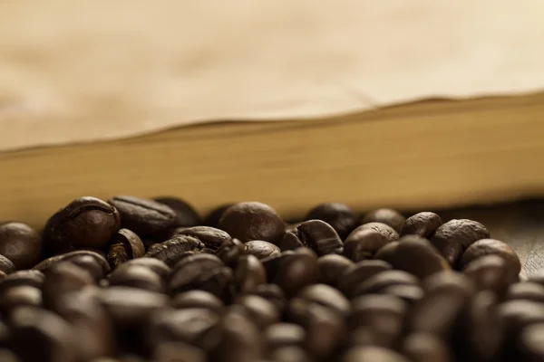 Rostade kaffebönor på gamla vintage öppen bok. Meny, recept, prototyper. Trä bakgrund. — Stockfoto