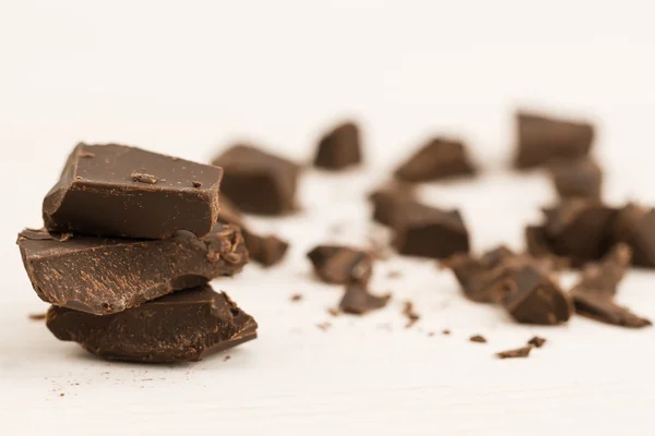 Broken chocolate bar on wooden background, close-up — Stock fotografie