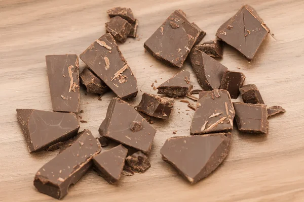 Broken chocolate bar on wooden background, close-up — Stock Fotó