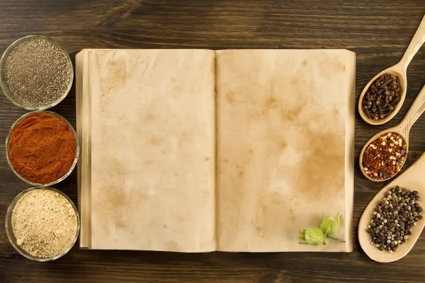 Libro vintage viejo abierto con especias sobre fondo de madera. Comida vegetariana saludable. Receta, menú, maqueta, cocina . — Foto de Stock