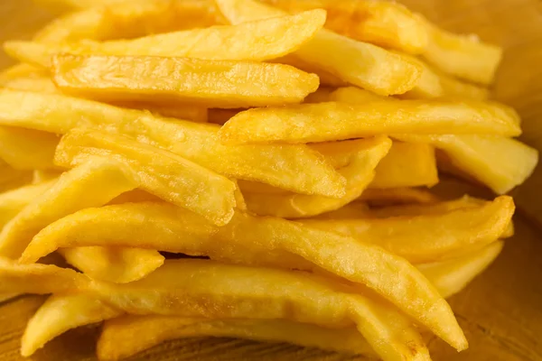 Batatas fritas com ketchup fresco e sal em uma colher em um saco de papel — Fotografia de Stock