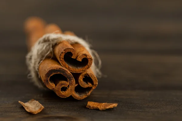 Cinnamon sticks on wooden background, close up — Stock Photo, Image