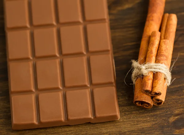 Chocolade en kaneel stokken op houten achtergrond — Stockfoto