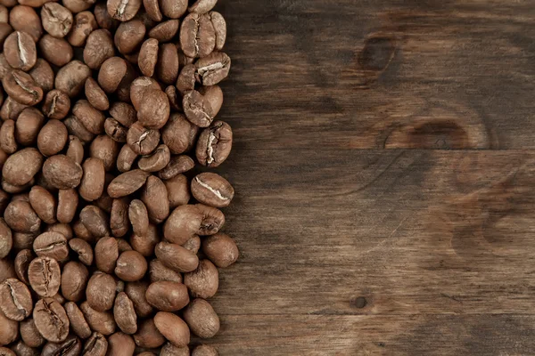 Café de fondo. Frijoles asados sobre fondo de madera viejo — Foto de Stock