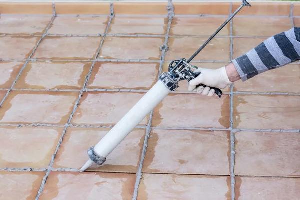 Döşeme tahtalarına silikon sürüyorum.