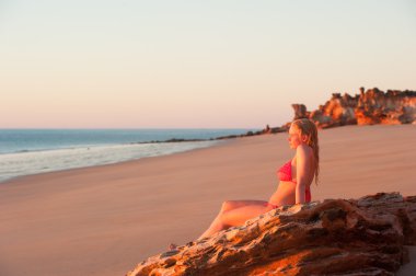Rahat genç kadın tropikal plaj günbatımı