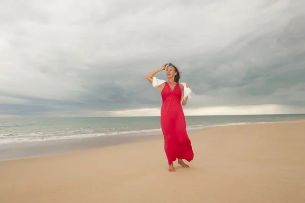 Žena na pláži a bouřkové mraky nad oceánem — Stock fotografie