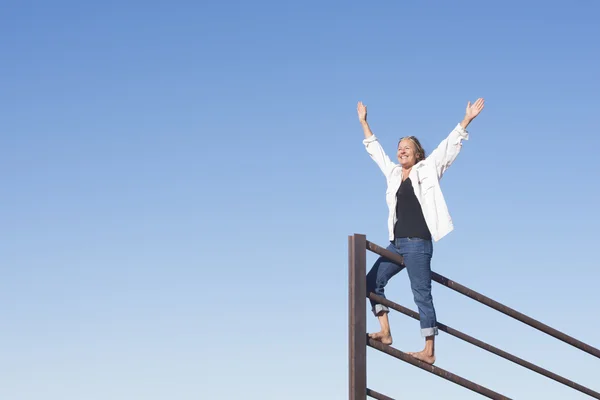 Joyful mature woman with arms up outdoor — Stock Photo, Image