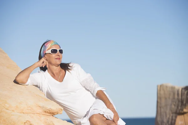 Расслабленная уверенная зрелая женщина на пляже — стоковое фото