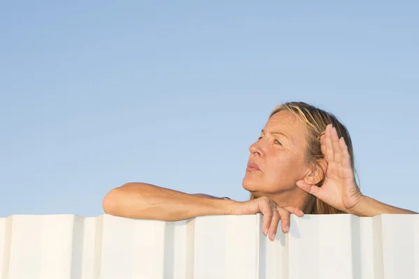 Frau hört und hört neugierig im Freien — Stockfoto