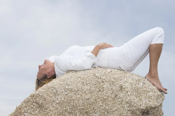 Woman lying relaxed on top of rock outdoor — Stock Photo, Image