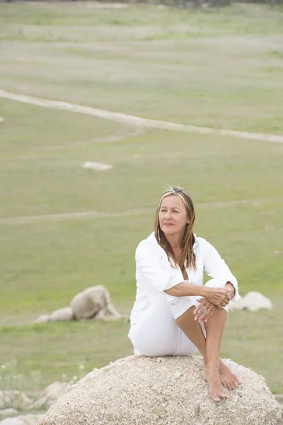 Thoughtful woman sitting alone outdoor — Stock Photo, Image