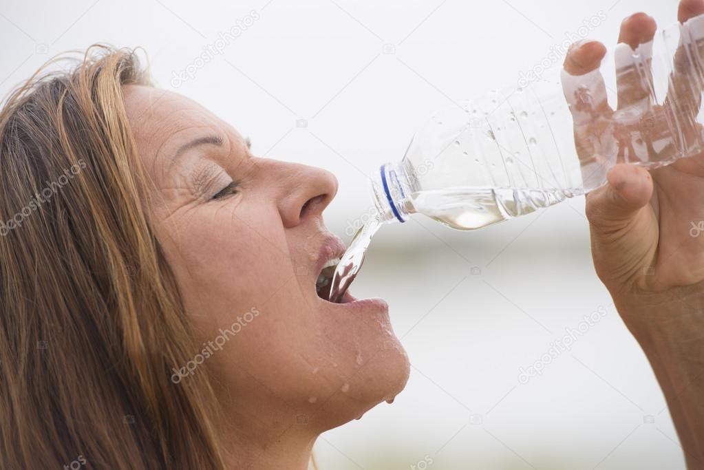 Active sporty woman drinking refreshing water