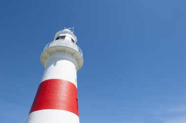 Yukarı doğru görünümü kırmızı beyaz deniz feneri mavi gökyüzü
