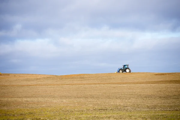 Tractor wide open crop field in rural farm area — Stock Photo, Image