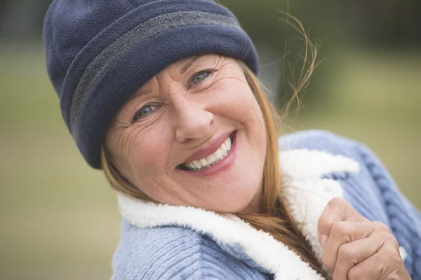 Gelukkige vrouw warme motorkap en jas buiten — Stockfoto