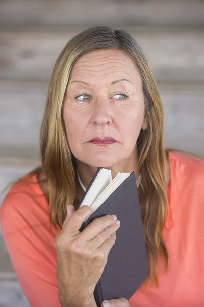 Volwassen vrouw met boek denken — Stockfoto