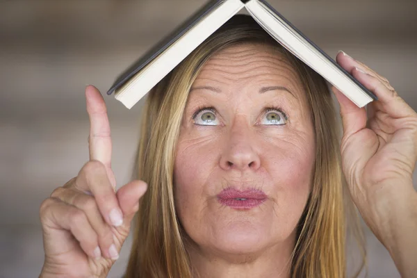 Portrait smart woman with book on head — Stock Photo, Image