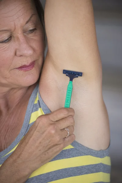 Cuidado de la piel mujer madura afeitándose bajo el brazo — Foto de Stock