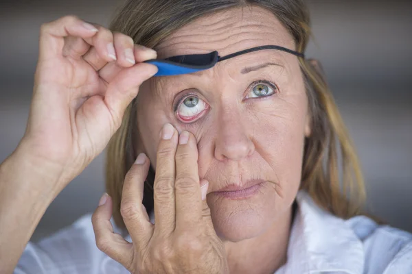 Mulher madura ferida levantando adesivo protetor ocular — Fotografia de Stock