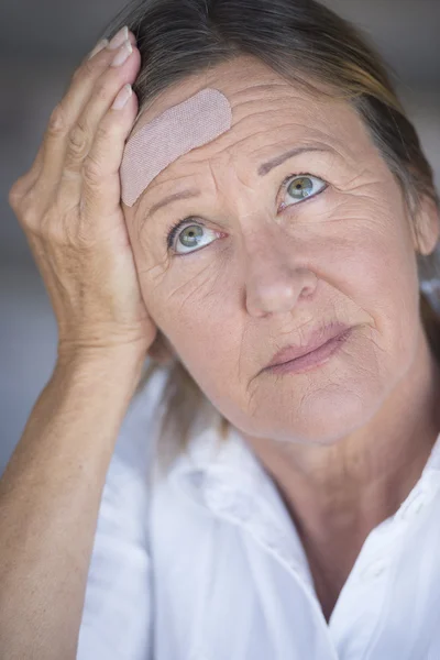 Frau mit Schmerzen und Pflaster auf der Stirn — Stockfoto