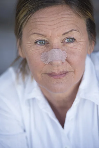 Mulher confiante com ajuda banda no nariz ferido — Fotografia de Stock