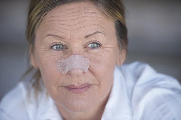 Selvsikker kvinne med plaster på nesen – stockfoto