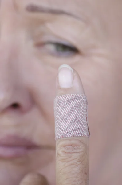 Femme stressée avec pansement doigt blessé — Photo