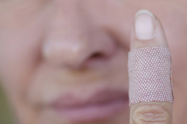 Injured female finger with band aid — Stock Photo, Image