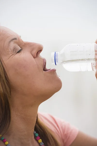 Active sporty mature woman drinking water — Stock Photo, Image